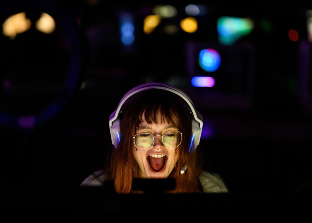 A woman laughing in front of a computer screen