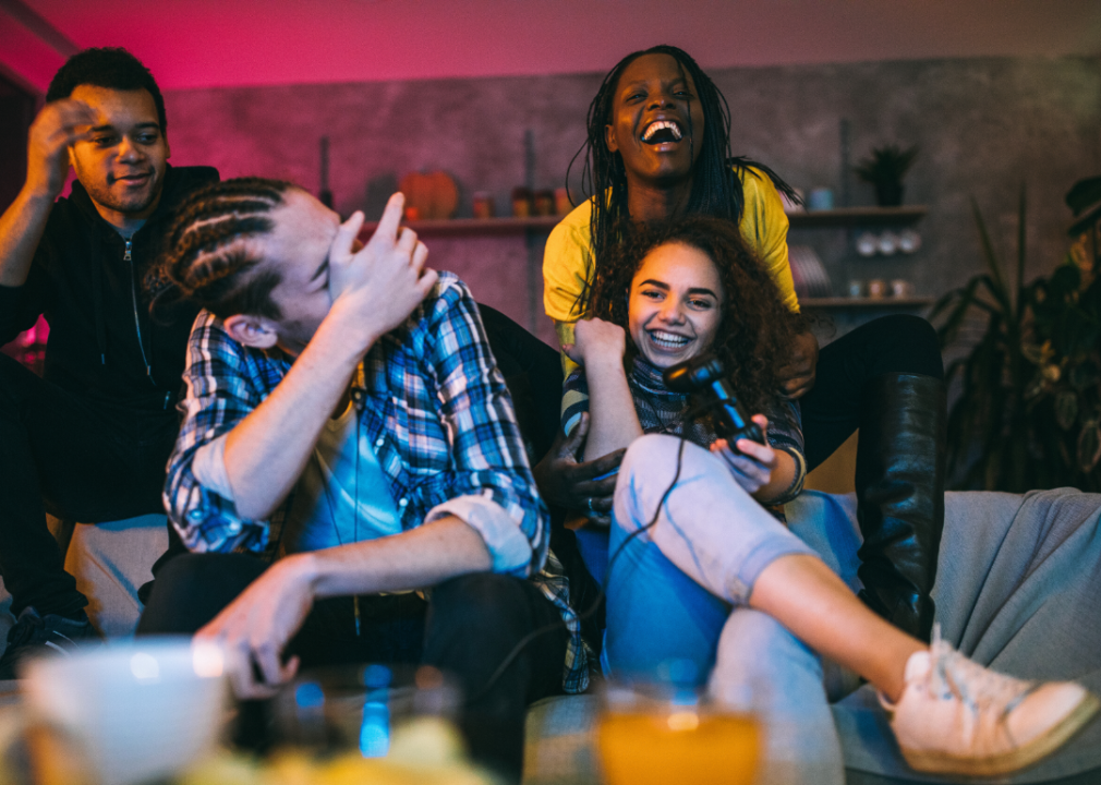 Young people laughing and playing video games