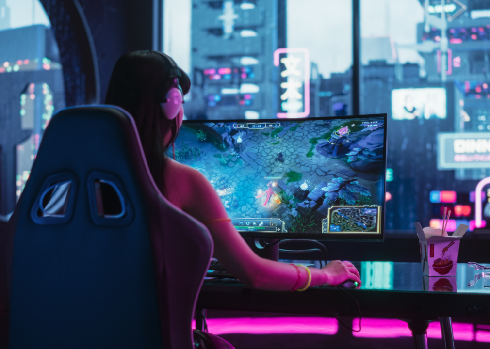 A young woman playing a video game at a desk